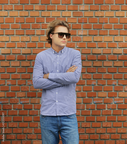Teenager standing near a brick wall 