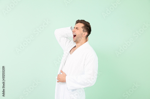 Sleepy man in bathrobe on c...