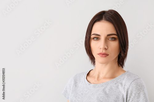 Beautiful young woman on grey background