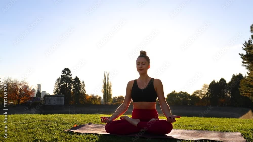 Woman Relaxing on Yoga Mat in Grass Park Field Doing Breathing Exercise to Release Tension and Thoughtful Insight into Her Mind Woman Relaxing on Yoga Mat in Grass Park Field Doing Breathing Exercise to Release Tension and Thoughtful Insight into Her Mind