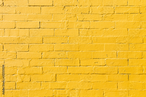 Retro bright yellow painted brick wall background texture