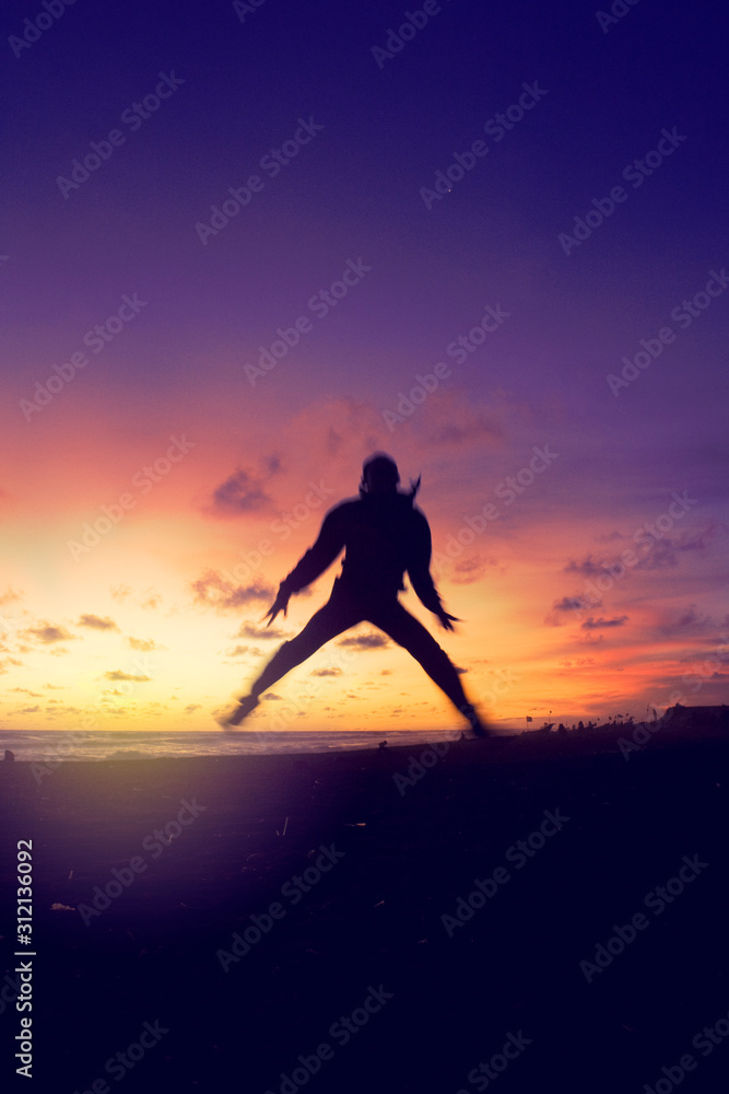 Silhouette of a man jump at sunset sky
