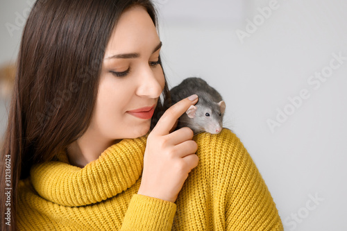 Foto Young woman with cute rat at home