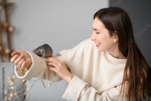 Young woman with cute rat at home