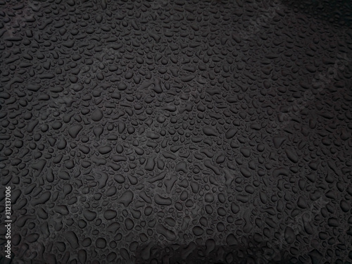 Beautiful background texture of rain water drops on grey black metal surface. Beautiful backgrounds. Drops of water on a color background. Dark grey.