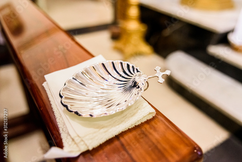Wall Mural Silver shell for holy water in Christian religious baptism.