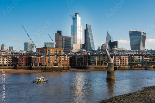 Tall Buildings in City of London Financial District and the Millennium Bridge Crossing Thames River