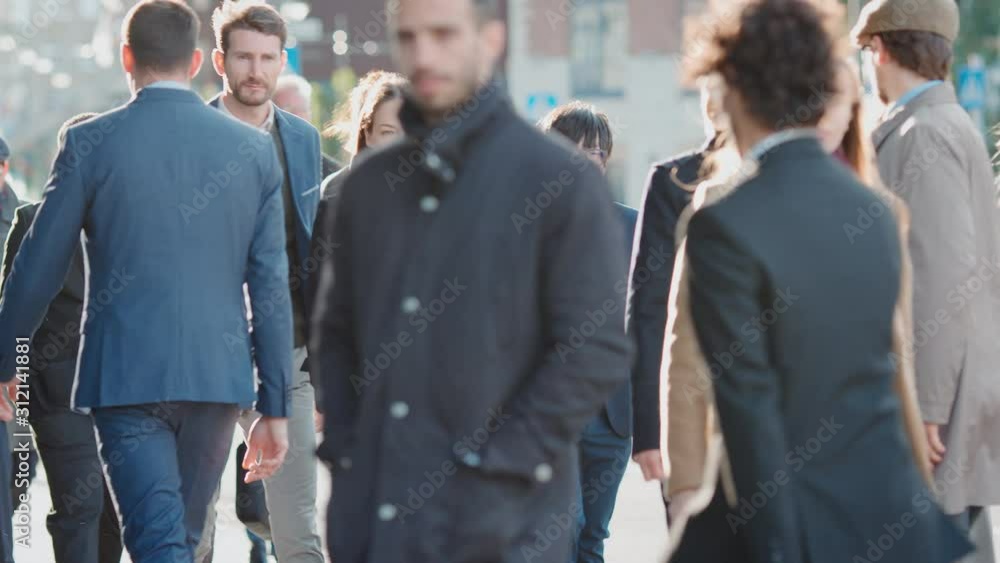 Diverse and Multicultural Office Managers and Business People Commute to Work in the Morning or from Office on a Sunny Day on Foot. Pedestrians are Smart Casually Dressed. They Look Successful. Diverse and Multicultural Office Managers and Business People Commute to Work in the Morning or from Office on a Sunny Day on Foot. Pedestrians are Smart Casually Dressed. They Look Successful.