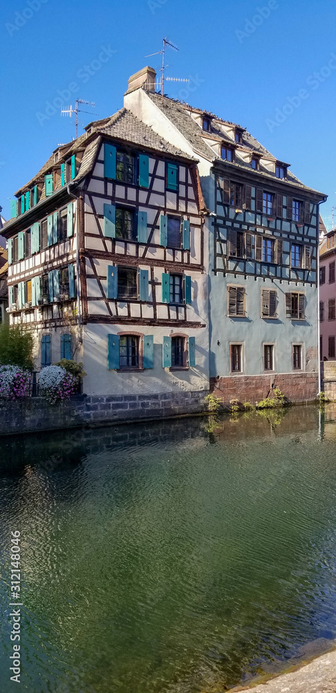 white timber framed house along Strasbourg Canal with blue shutters
