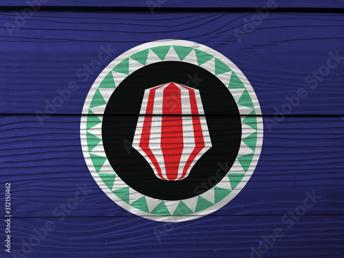 Bougainville flag color painted on Fiber cement sheet wall background. Red and white upe headdress superimposed on a green and white kapkap, on cobalt blue.
