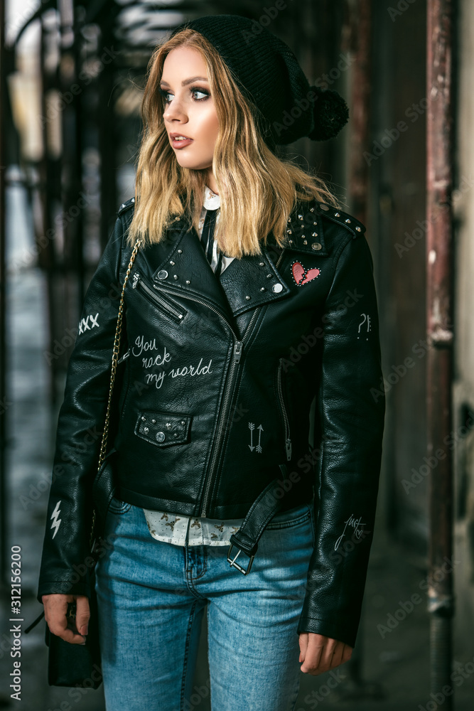 Urban style girl standing near a gangway in a black leather jacket Urban style girl standing near a gangway in a black leather jacket