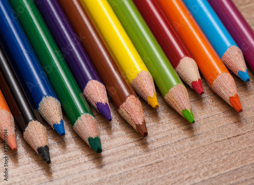 Concept back to school - frame of multicolored pensils on wood background photo