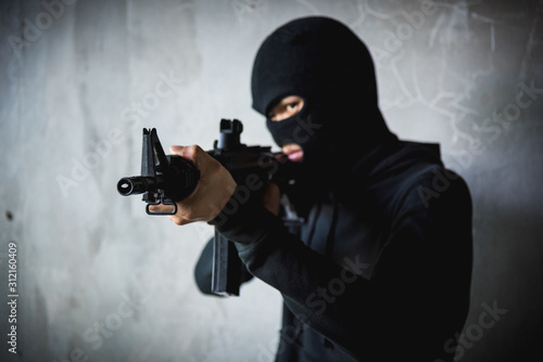 Robber assassin crime with hood points the gun © sorapop