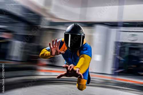 Velocity. Flight speed of skydiver. Parachutist in blue and yellow suit is in free fall. Extreme as a hobby. © Viktor