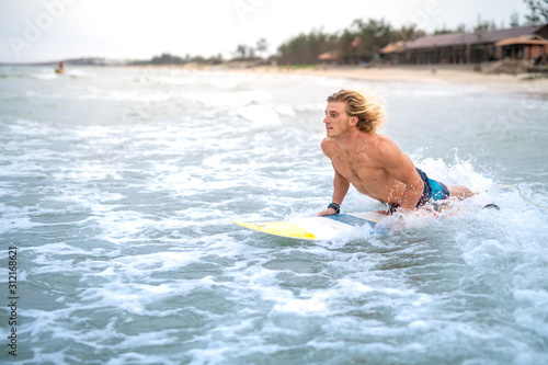 Blond caucasian surfer checking out the waves on a surf spot in Vietnam, Asia © OskarFeldezdi