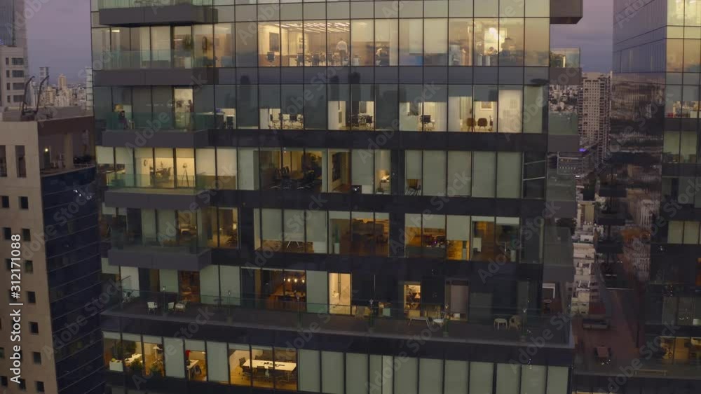 Workers at office building at night, view trough a window, Tel Aviv skyline, Israel 4k aerial drone Workers at office building at night, view trough a window, Tel Aviv skyline, Israel 4k aerial drone