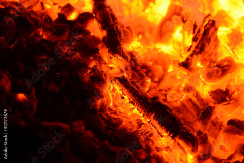 The hot coals of a burning bonfire close-up. Abstract background