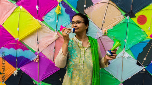 woman with Patang(kite) and firki and pipuda toy for Makar Sankranti festival of India. Makar Sankranti is kite festival of India. It is also known as uttarayan photo