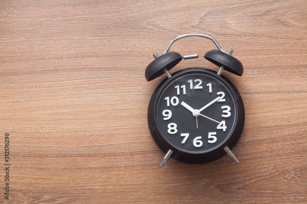 Black color bell alarm clock on wood background Black color bell alarm clock on wood background