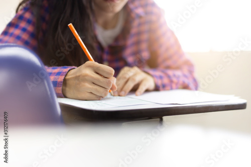 high school,university student study.hands holding pencil writing paper answer sheet.sitting lecture chair taking final exam attending in examination classroom.concept scholarship for education abroad