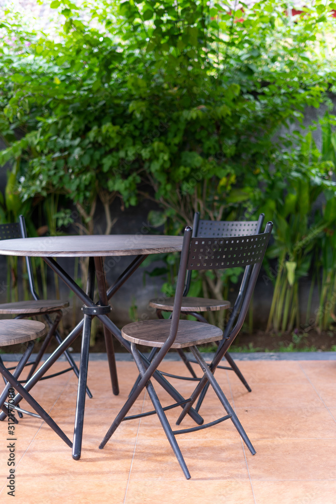 Metal chairs and table in gazebo on backyard