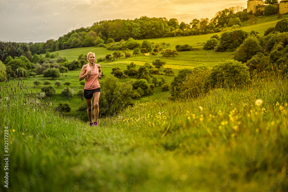 A middle-aged woman runs through the hills