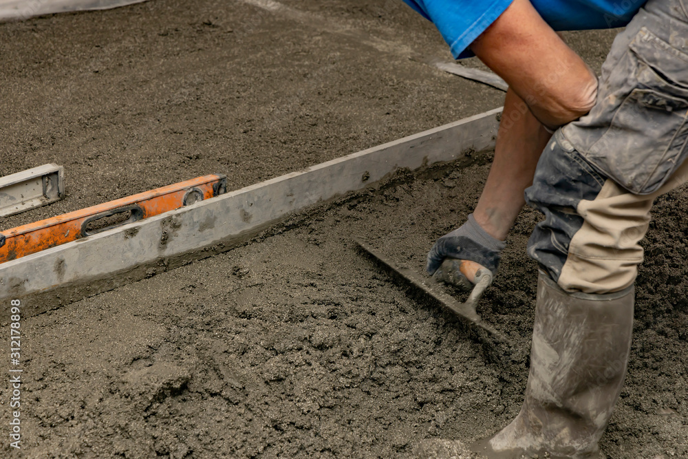 Floor screed is processed in the apartment. The worker performs a sand-cement floor screed. Floor screed is processed in the apartment. The worker performs a sand-cement floor screed.