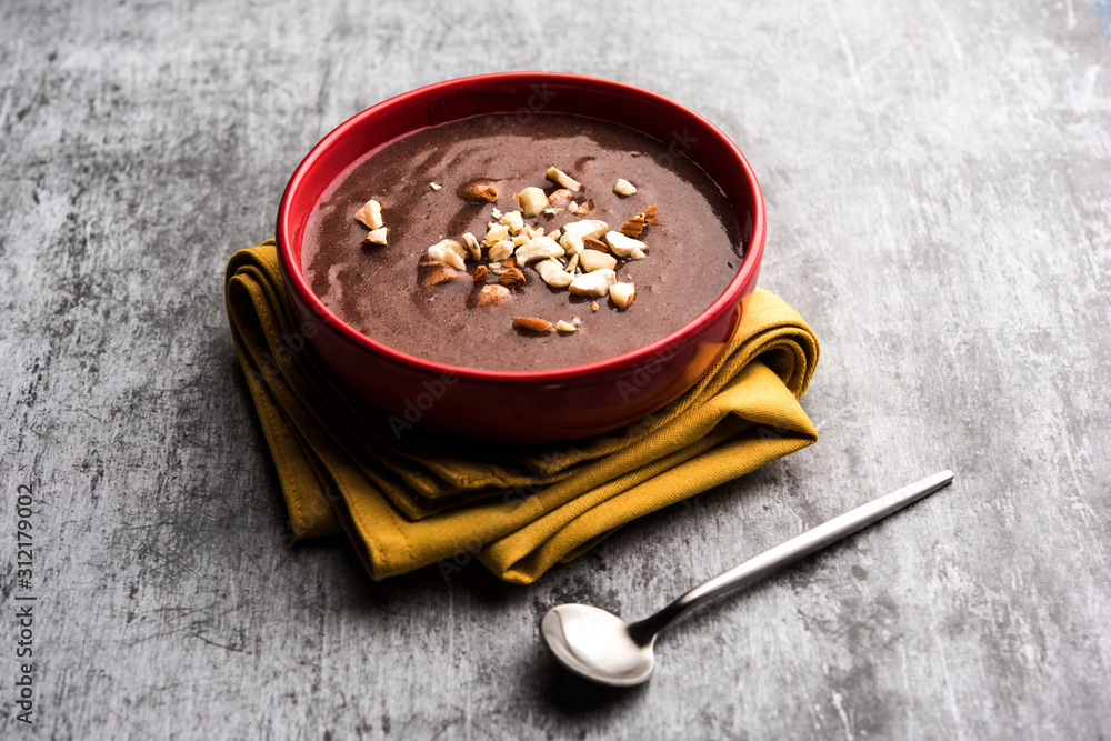 Φωτογραφία Sweet Ragi Malt / Healthy Ragi Porridge in a bowl garnished with crushed dry fru
