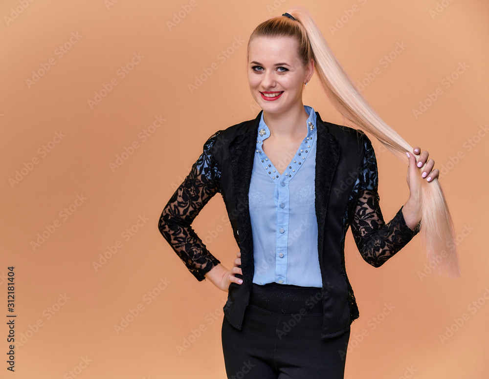 Concept business blonde girl stands in front of the camera. Portrait of a manager woman in a business suit with long beautiful hair and excellent make-up on a pink background. Concept business blonde girl stands in front of the camera. Portrait of a manager woman in a business suit with long beautiful hair and excellent make-up on a pink background.