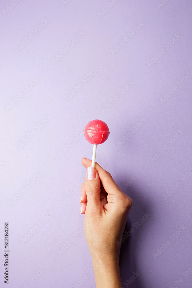 Chupa Chups in a hand on a lilac background, empty space for text foto de  Stock | Adobe Stock