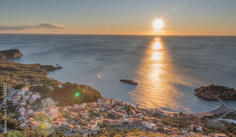 Golden sunrise sunset over the Adratic sea in Montenegro, view from the top of the mountain above St. Stephen island.Quiet place. Relaxing scene.Calm sea water. Beautiful colors in the sky.