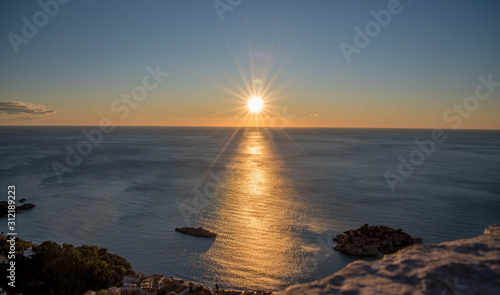 Obraz na płótnie Golden sunrise sunset over the Adratic sea in Montenegro, view from the top of the mountain above St. Stephen island.Quiet place. Relaxing scene.Calm sea water. Beautiful colors in the sky. w salonie