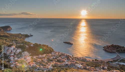 Golden sunrise sunset over the  Adratic sea in Montenegro, view from the top of the mountain above St. Stephen island.Quiet place. Relaxing scene.Calm sea water. Beautiful colors in the sky.  photo