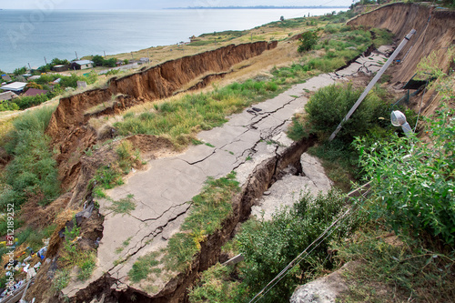 Photos the sunk asphalt road after a landslide, natural disaster landslide of soil with an asphalt road off the coast