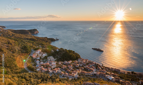 Obraz na płótnie Golden sunrise sunset over the Adratic sea in Montenegro, view from the top of the mountain above St. Stephen island.Quiet place. Relaxing scene.Calm sea water. Beautiful colors in the sky. w salonie