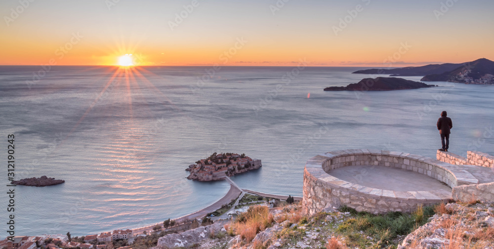Golden sunrise sunset over the Adratic sea in Montenegro, view from the top of the mountain above St. Stephen island.Quiet place. Relaxing scene.Calm sea water. Beautiful colors in the sky.