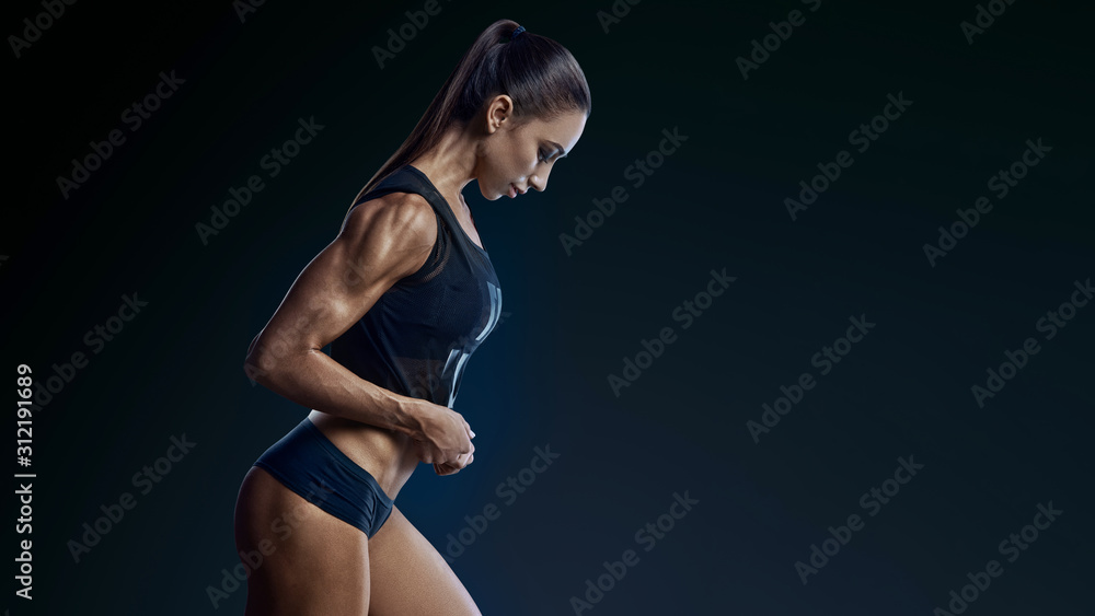 Obraz premium Fitness female bodybuilder in motion in half-face