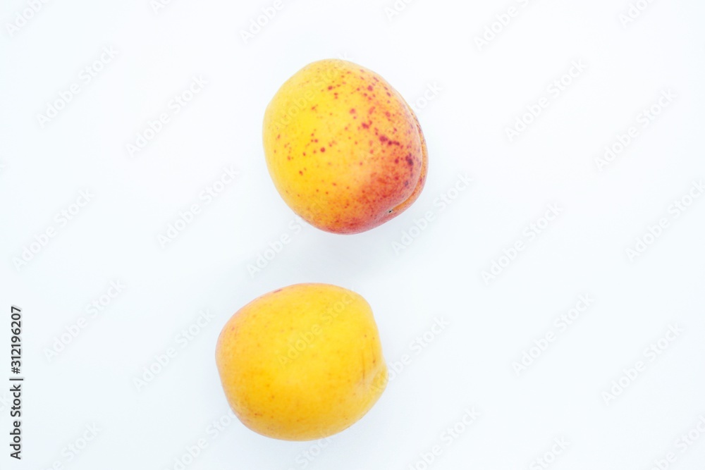 Tasty ripe beautiful apricots located on a white background