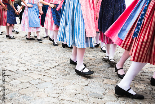 Many dancing legs of little baby girls and young women in period costumes performing folklore dances in Cesky Krumlov, Czech Republic to welcome spring and Easter Holiday.