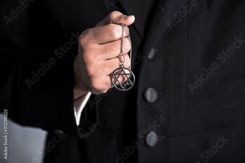 cropped view of jewish man holding star of david necklace