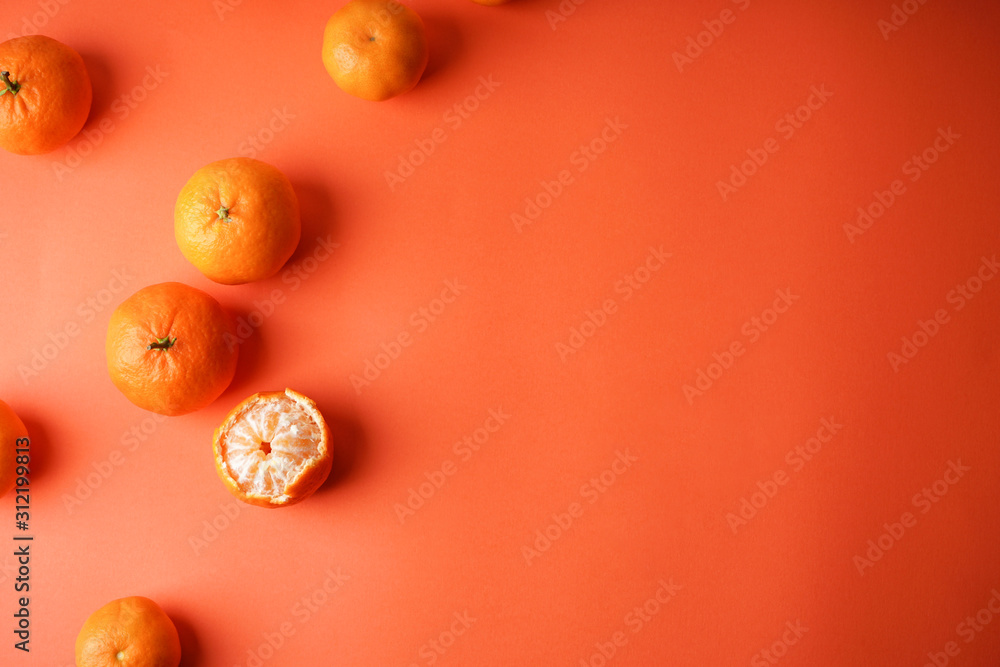 A lot of fresh tangerines, one peeled on an orange background with place for text flat lay. A lot of fresh tangerines, one peeled on an orange background with place for text flat lay.
