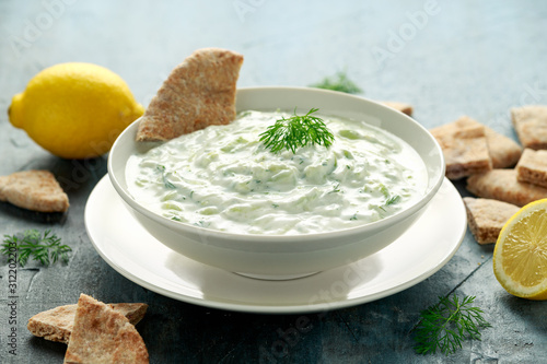 Tableau sur toile Tzatziki dip sauce with greek yogurt, garlic, dill and cucumber in white bowl
