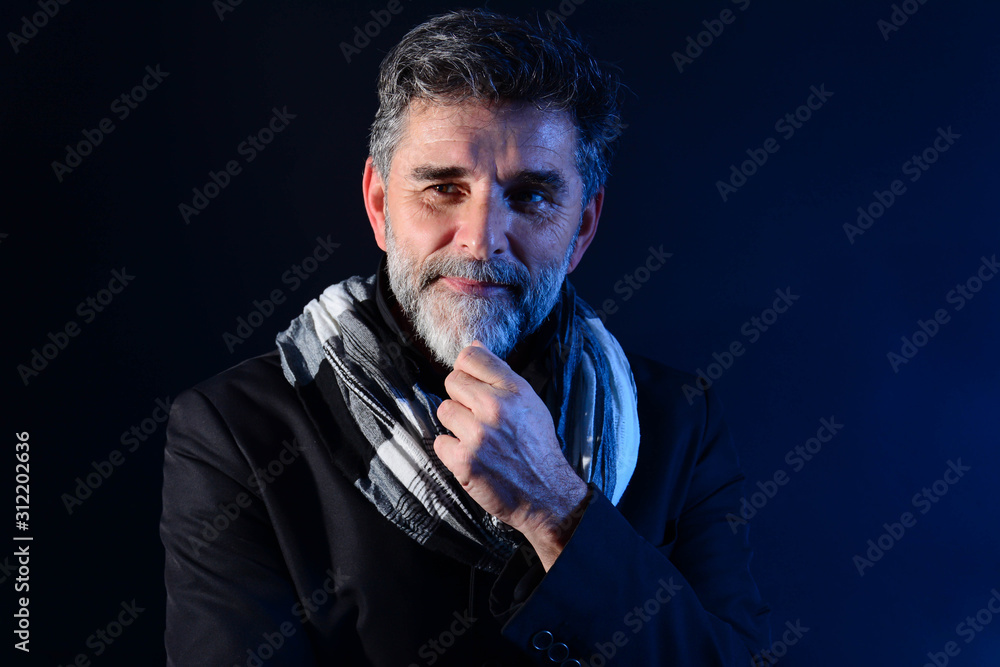 Fototapeta premium Portret przystojny mężczyzna z uśmiechem. Brodaty starszy mężczyzna patrząc na kamery z poważnym wyrazem twarzy z bliska portret głowy i ramion