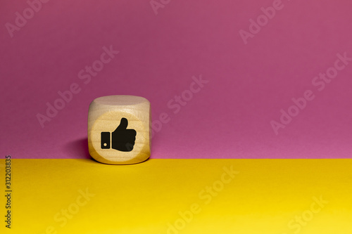 Pictogramme de like / pouce en l'air sur cube en bois