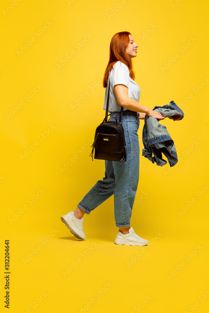 It's easier to be follower. Need minimum clothes to go. Caucasian woman's portrait on yellow background. Beautiful female red hair model. Concept of human emotions, facial expression, sales, ad. It's easier to be follower. Need minimum clothes to go. Caucasian woman's portrait on yellow background. Beautiful female red hair model. Concept of human emotions, facial expression, sales, ad.