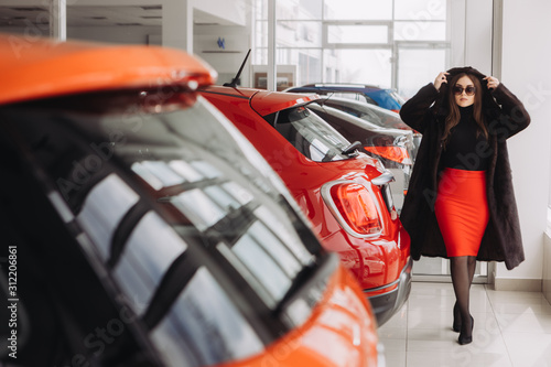 A young businesswoman is testing cars in a car store