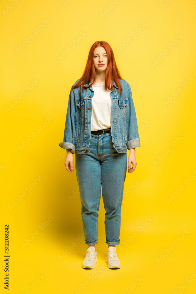 It's easy to be follower. Minimal and comfort style in clothes. Caucasian woman's portrait on yellow background. Beautiful red hair female model. Concept of human emotions, facial expression, sales It's easy to be follower. Minimal and comfort style in clothes. Caucasian woman's portrait on yellow background. Beautiful red hair female model. Concept of human emotions, facial expression, sales