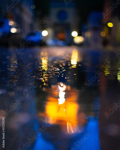Rainy street with reflections of cars and lights