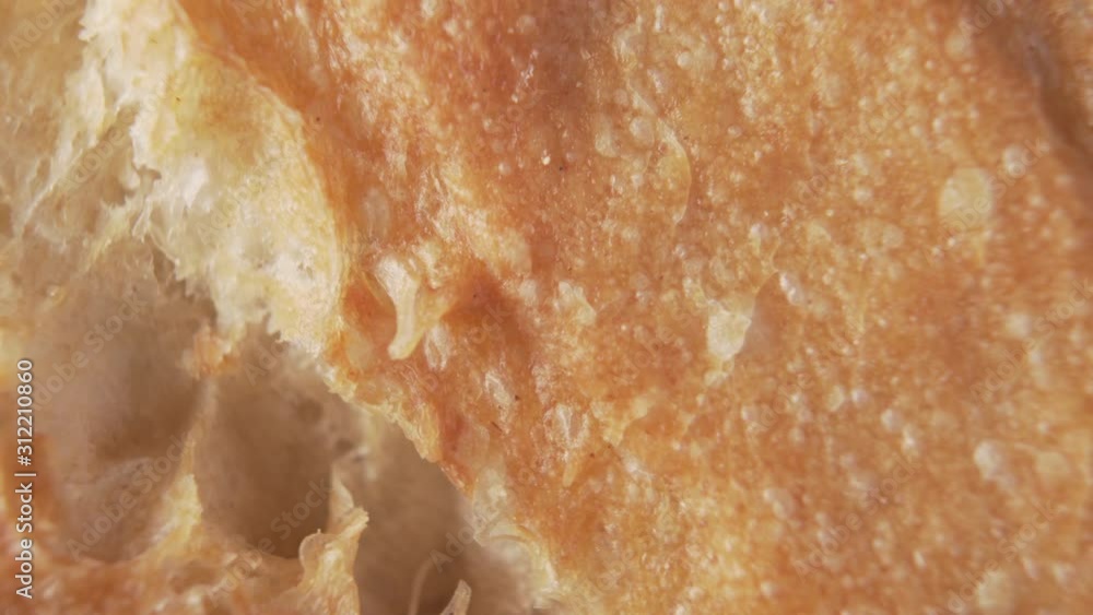 A crust of fresh bread with cracks rotates closeup A crust of fresh bread with cracks rotates closeup
