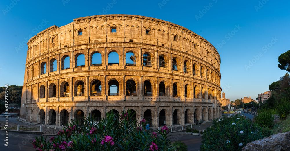 Beautiful panorama of Colloseum during sunrise without people. Sun lits on the amphitheater. No people at Colloseum.